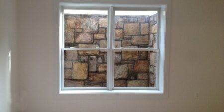 Window looking into stone wall